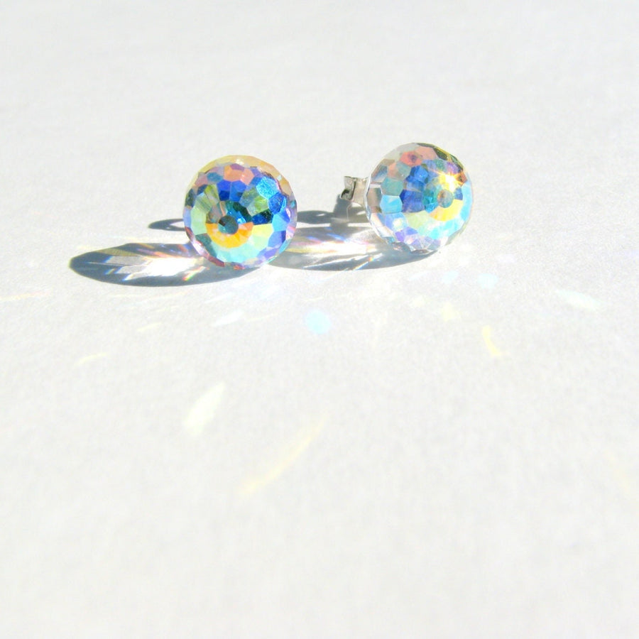 Close-up of Swarovski AB faceted crystal ball stud earrings showing the iridescent Aurora Borealis finish with rainbow light reflections.