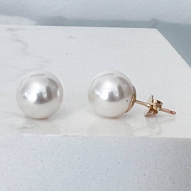 Close up, round white Swarovski pearl stud earrings featuring solid .925 sterling silver posts.