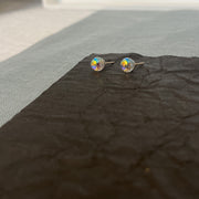 one pair of Swarovski AB crystal ball earrings, in a gold setting on a black background.