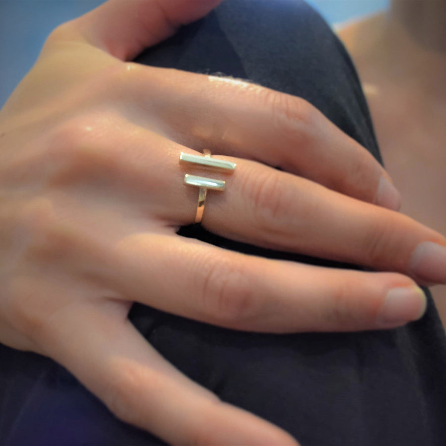 Close-up of a hand wearing a gold ring with a blurred background