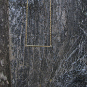 Minimalist gold bar necklace on display card in matte black Sela and Sage jewelry gift box.