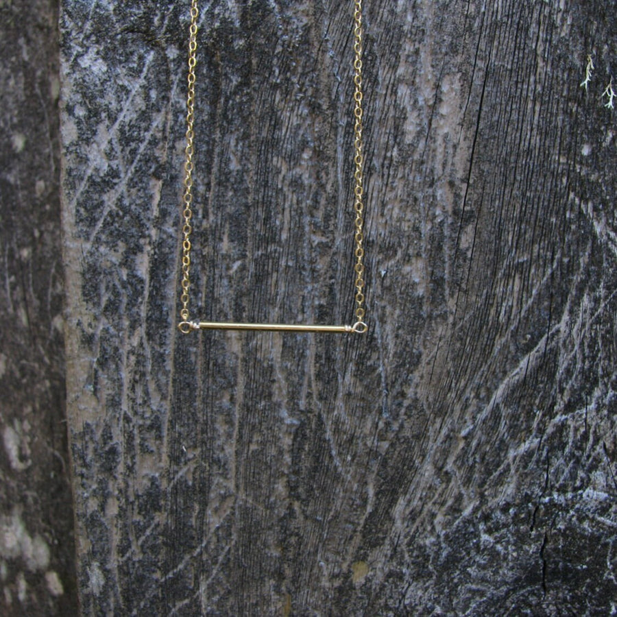 Minimalist gold bar necklace on display card in matte black Sela and Sage jewelry gift box.
